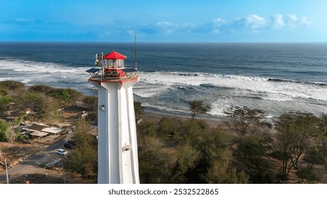 A tall lighthouse stands guard over crashing ocean waves under a clear sky - Powered by Shutterstock