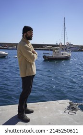 Tall Man Standing With Arms Crossed On Pier