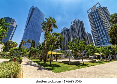 Tall modern business and residential buildings under blue sky as seen from Sarona market in Tel Aviv, Israel (low angle view).