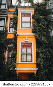 a tall orange building with a clock on the top of it, a flemish Baroque by Albert Bertelsen, trending on unsplash, fauvism, complementary colors, vibrant colors, rich color palette
				