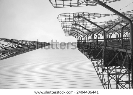 Tall rusty edifices featuring a complex network of wires. Duga is a Soviet over-the-horizon radar station for an early detection system for ICBM launches.