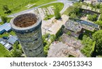 Tall silo smokestack aerial near abandoned, old, rubble building green ivy walls Pierceton IN