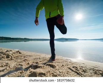 Tall Slim Man Doing Stretching On The Beach On A Sunny Morning.  Body Stretching Before Doing Sports.