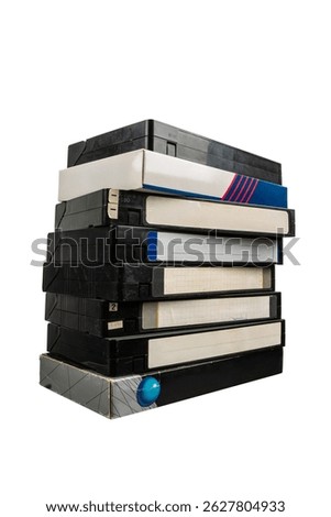 A tall stack of old VHS video tapes with worn labels and cases, isolated on white background.