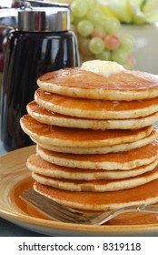 A Tall Stack Of Pancakes Covered In Syrup And Butter