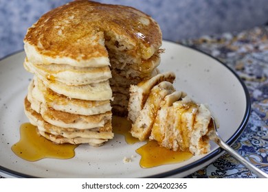 Tall Stack Of Pancakes Drizzled With Syrup