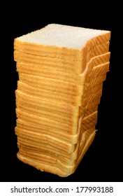 Tall Stack Of White Bread On A Black Background.