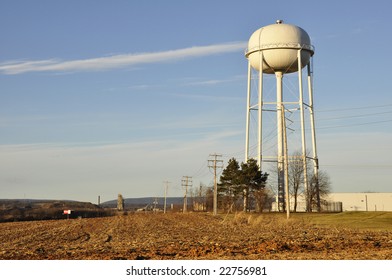 Tall White Water Storage Tower In A Rural Setting