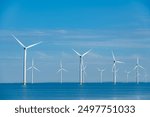 Tall windmill turbines against a clear blue sky, generating renewable energy in the serene Dutch landscape by the sea. windmill park Westermeerdijk in the Noordoostpolder Netherlands