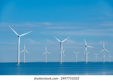 Tall windmill turbines against a clear blue sky, generating renewable energy in the serene Dutch landscape by the sea. windmill park Westermeerdijk in the Noordoostpolder Netherlands - Powered by Shutterstock