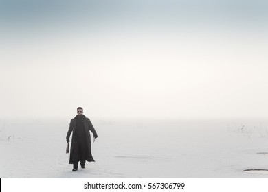 Tall Young Man In A Leather Coat Walking With Ax