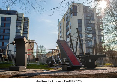 Tallinn, Estonia - April 30, 2021: Empty Outdoor Gym. Outdoor Gym Equipment In The Public Tuvi Park, Tallinn City Center. New Modern Apartment Buildings In The Background. Selective Focus.