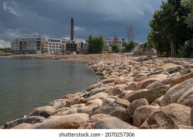 Tallinn, Estonia - August 01 2021: Tallinn Cityscape. View Of Kalaranna District And New Apartment Buildings. Baltic Sea And Big Stones In The Foreground. Focus On The Stones.