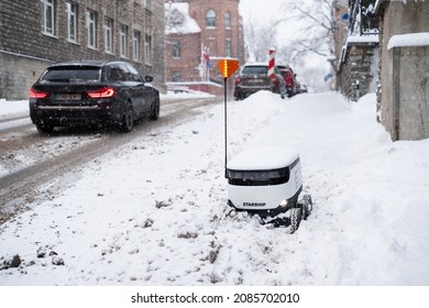 Tallinn, Estonia - December 4, 2021: Starship Technologies Autonomous Drone Vehicle Stuck In Snow In Winter. Starship Self Driving Contactless Food Delivery Robot.