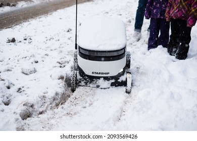 Tallinn, Estonia - December 4, 2021: Starship Technologies Autonomous Drone Vehicle Stuck In Snow In Winter. Starship Self Driving Contactless Food Delivery Robot.