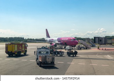 Tallinn, Estonia - July 19, 2019: Emergency And Baggage Handling Vehicles Attend To A Wizz Air Aircraft On Arrival At Tallinn Airport Or Talllinna Lennujaam.