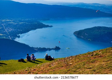 Talloires, France - September 08 2020 : people are sitting and having a picnic enjoying the view over the alpine lake of Annecy