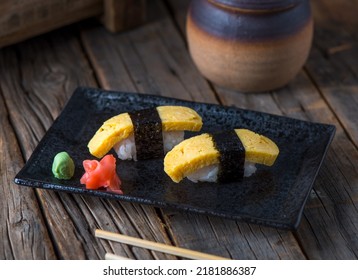 TAMAGO authentic nigiri served in a dish isolated on wooden background side view of authentic nigiriSalmon authentic nigiri served in a dish isolated on wooden background side view of authentic nigiri