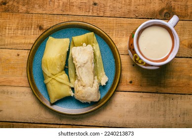 Tamales de elote and atole on a wooden table. Typical Mexican food.