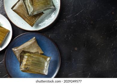 Tamales oaxaquenos, traditional dish of the cuisine of Mexico, various stuffings wrapped in green leaves. Hispanic food, overhead flat lay shot with copy space