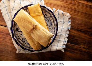 Tamales. Prehispanic dish typical of Mexico and some Latin American countries. Corn dough wrapped in corn leaves. The tamales are steamed.  - Shutterstock ID 2112249629