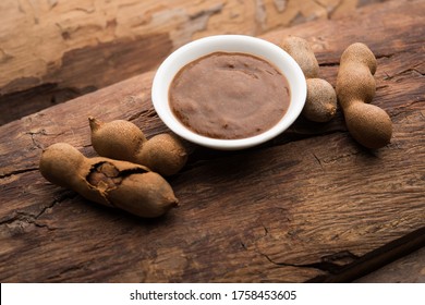 Tamarind Or Imli Fresh Puree, Paste From Pulp, Served In A Bowl With Whole Fruit