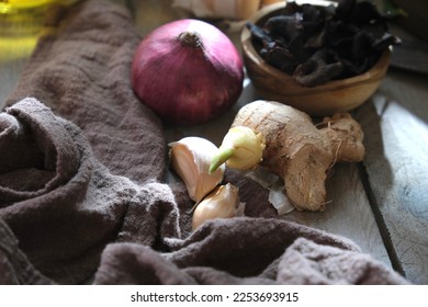 Tamarind slice, onion, garlic and ginger on wooden table. - Shutterstock ID 2253693915