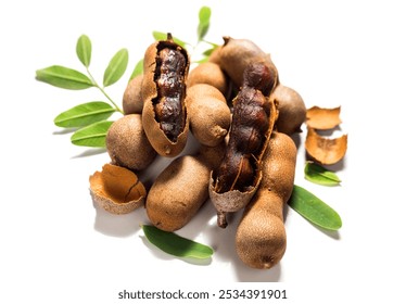 Tamarind tropical fruits isolated on white background. Fresh Tamarind pods with leaves (Tamarindus indica, Indian date), healthy vegan food close up   - Powered by Shutterstock