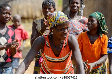 TAMBERMA VIL, TOGO - JAN 13, 2017: Unidentified Tammari A Woman With A Headscarf On Her Head Dances Near People In The Village. Tammaris Are Ethnic Group Of Togo And Benin