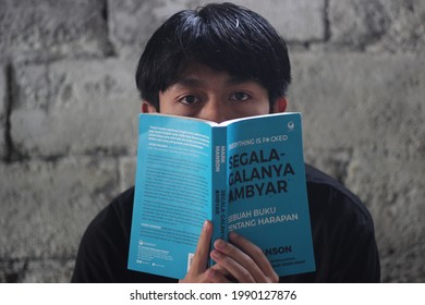 Tambi,wonosobo,indonesia-06-13-2021:someone Covers Face With A Reading Book Buku