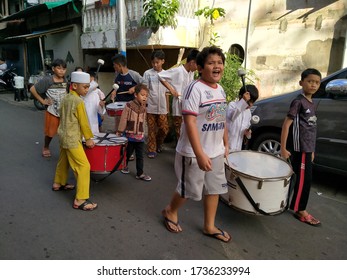 Tambora, West Jakarta, Indonesia - May 19, 2020 :  A Group Of Children Busking Around The Street, Carrying A Drum Band, During The Corona Virus Pandemic.