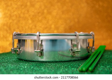 Tamborim. Brazilian instrument of percussion used to play samba used in the carnival. Tambourine and drumstick with background representing the brazilian flag.  Space for text