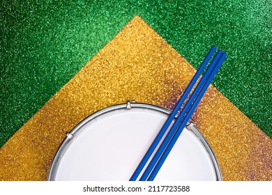 Tamborim. Brazilian instrument of percussion used to play samba played in the carnival. Tambourine and drumstick with background representing the brazilian flag. View from tall. Space for text
