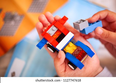 Tambov, Russian Federation - December 19, 2013 Child Building Lego Car. There Are  Some Lego Instructions On Background.