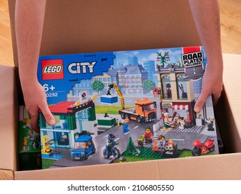 Tambov, Russian Federation - December 21, 2021 A Person Picking Up A Lego City Town Center Set From A Box 