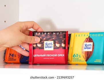 Tambov, Russian Federation - February 19, 2022 A Woman Taking A Ritter Sport Hazelnut Chocolate Bar From Shelf Of Kitchen Cupboard