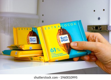 Tambov, Russian Federation - January 25, 2021 Woman Hand Taking Ritter Sport Chocolate Bar From Shelf Of Kitchen Cupboard