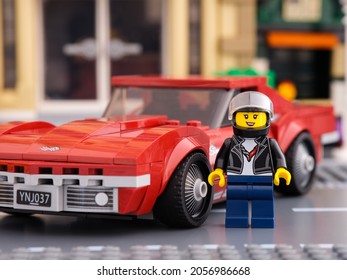 Tambov, Russian Federation - July 02, 2021 Lego 1968 Chevrolet Corvette Race Car Driver Minifigure By LEGO Speed Champions Standing Near Her Car.