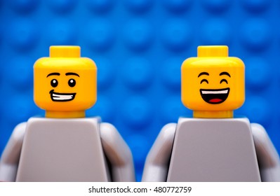 Tambov, Russian Federation - July 24, 2016 Two Lego minifigures - one with smirk and one happy. Blue background. Studio shot.