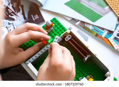 Tambov, Russian Federation - June 20, 2020 Child Building Lego House On The Table With Instruction Books. Shallow Depth Of Field