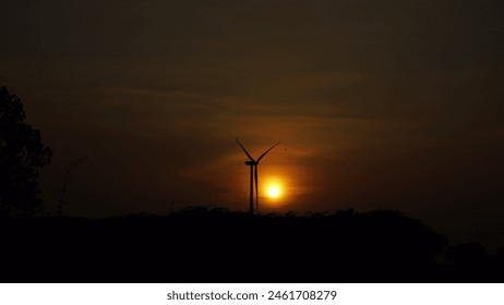 Tamil Nadu village wakes to a golden sunrise. Coconut trees sway gently, their fronds silhouetted against the vibrant sky. Windmills spin slowly, catching the first breath of morning. - Powered by Shutterstock