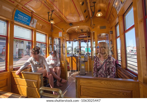 Tampa, Florida - March 7, 2018 :\
Passengers seated on wooden seats in the Teco Line\
streetcar