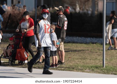 Tampa, Florida  USA - January 31, 2021: Man Wearing Sunglasses and Facial Mask, due to Covid-19, in a Tampa Bay Buccaneers Jersey and Baseball Hat in Downtown Tampa During Super Bowl LV Events