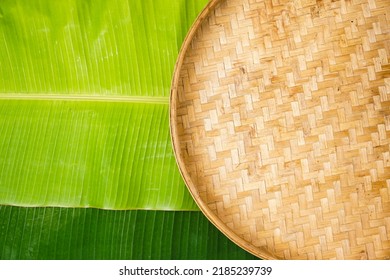 Tampah, Winnowing, Or Nyiru Is A Tool Used For Winnowing, Namely Cleaning Rice From Husks Or Other Grains Of Cereal From The Skin. Banana Leaf Background. Top View.