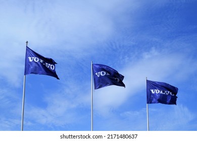 Tampere, Finland - May 18 2022: The view on the blue flags with Volvo text waving in the wind with the blue sky on the background hung on the posts nearby Volvo car dealer center