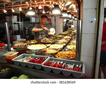 TAMPINES, SINGAPORE - DECEMBER 21, 2015: A Man Serves Food For A Customer At A Hawker In The Town Of Tampines In Singapore