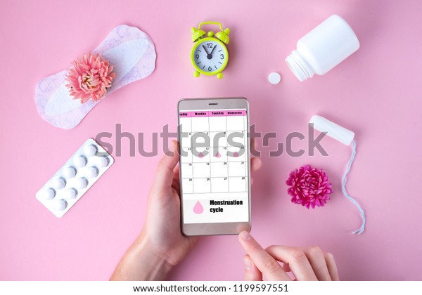 Tampon,\
feminine, sanitary pads for critical days, feminine calendar, alarm\
clock, pain pills during menstruation and a pink flower on a pink\
background. Care of hygiene during menstruation.\

