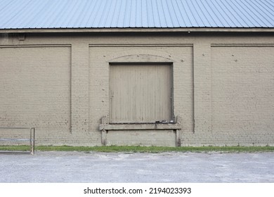Tan Brick Warehouse Loading Dock Gravel Parking Lot Tin Roof