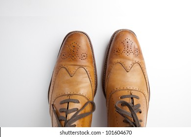 Tan Fashionable Male Brogue Shoes On White Background View From Above