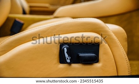 Tan leather seat showing the passenger seat, seat controls